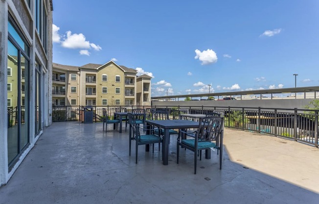 a patio with tables and chairs at the bradley braddock road station apartments