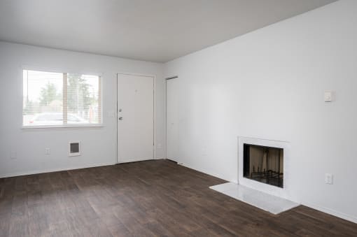 an empty living room with white walls and a fireplace