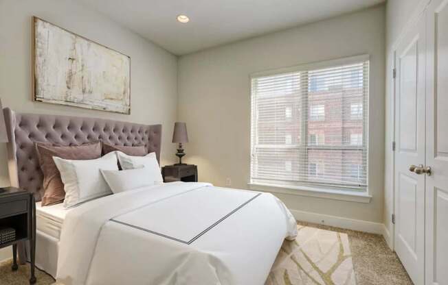 A bedroom with a large bed and a painting on the wall.