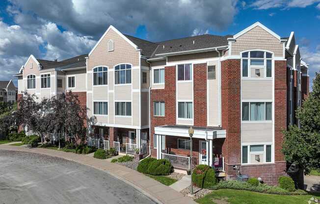 A large apartment building with a parking lot in front.