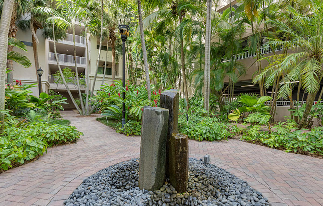 A stone monument sits in the middle of a garden.