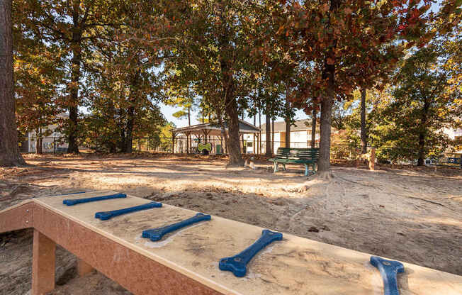 A sandbox with blue slides in the middle of a park.