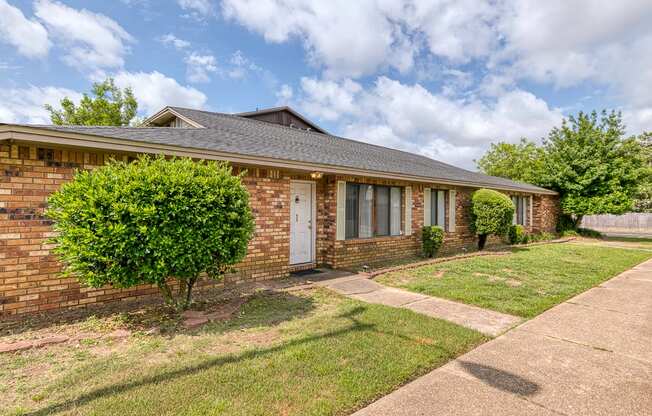 A brick house with a white door and windows.