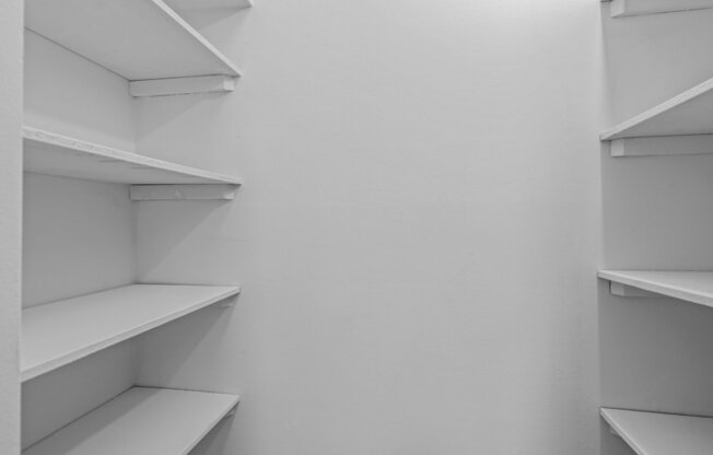 white shelves in a white closet in a room