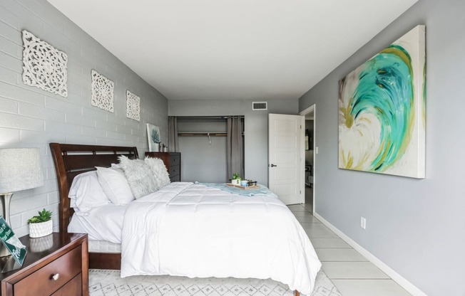a bedroom with a large bed and a painting on the wall