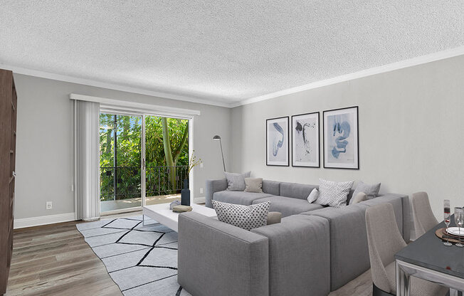 Hardwood floored living room with view of outdoor patio.