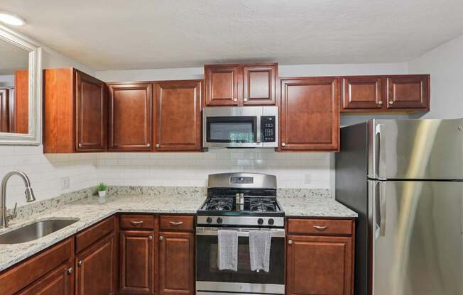 A kitchen with a stove top oven and a refrigerator.