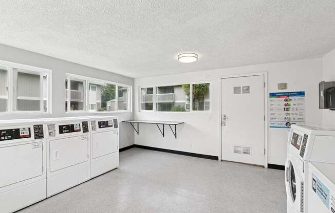 A laundry room with washers and dryers.
