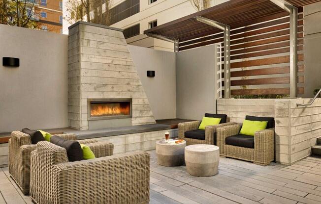 A patio with a fireplace and wicker chairs.