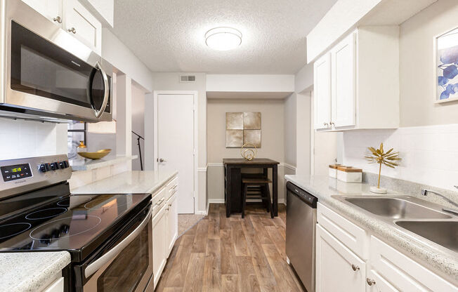Renovated Kitchen with Stainless Steel Appliances, White Cabinets and Wood Style Flooring