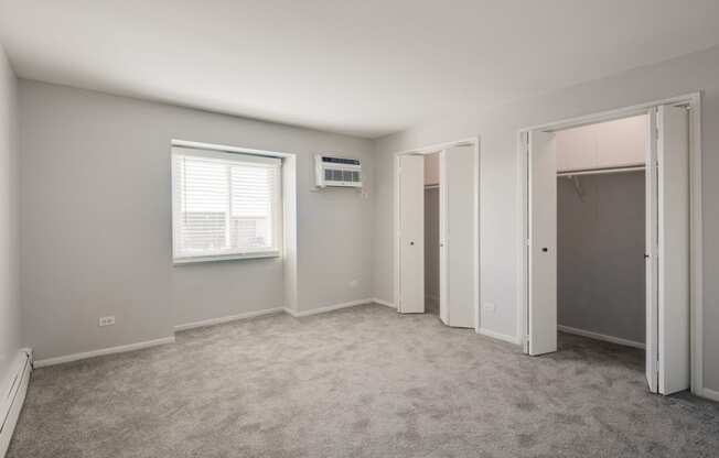 an empty bedroom with a closet and an air conditioner in it