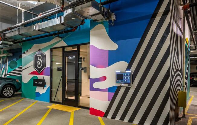 a wall in a parking garage with a mural on it