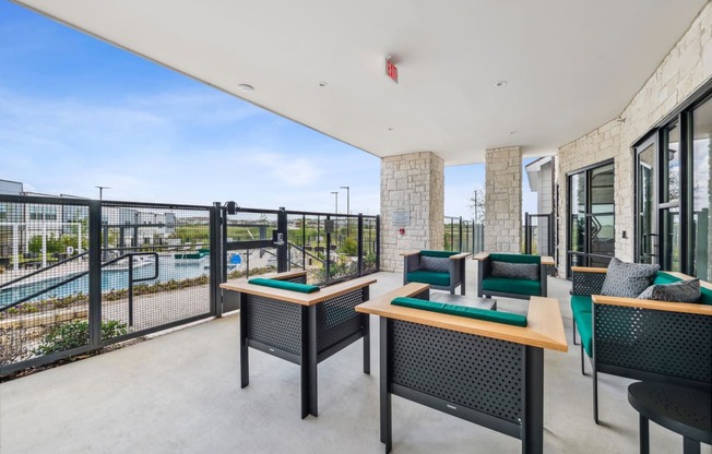 a balcony with tables and chairs and a view of a pool