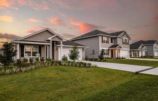 a row of houses with a sunset in the background