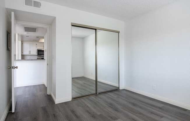 an empty living room with white walls and a sliding glass door