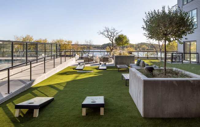A modern outdoor seating area with concrete planters and benches overlooking a body of water.