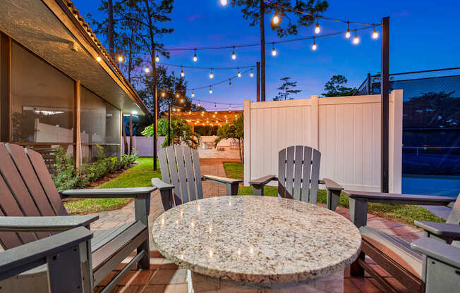 A patio with a table and chairs is set up for an evening outside.