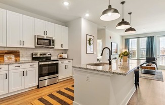 A kitchen with white cabinets and a granite countertop.