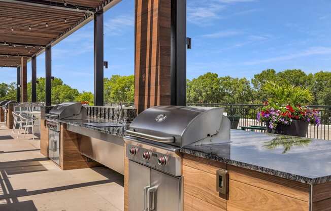 an outdoor kitchen with stainless steel appliances and a bar