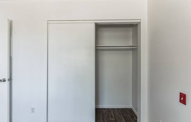 an empty closet in an empty room with a door open