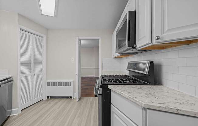 A kitchen with a stove top oven and a microwave above it.