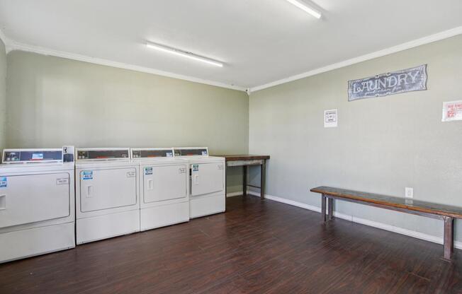 A laundry room with a bench and washing machines.