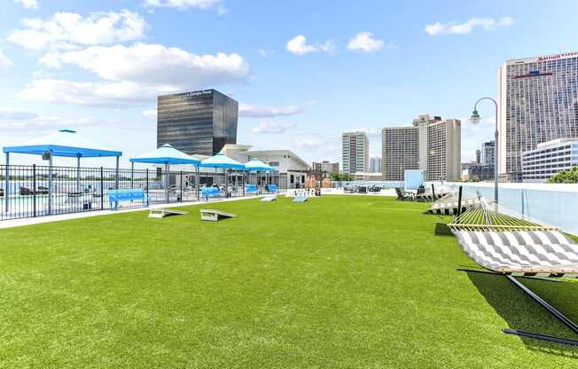 A large grassy area with a fence and a few umbrellas.