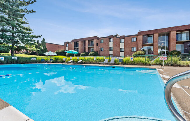 a large swimming pool with an apartment building in the background