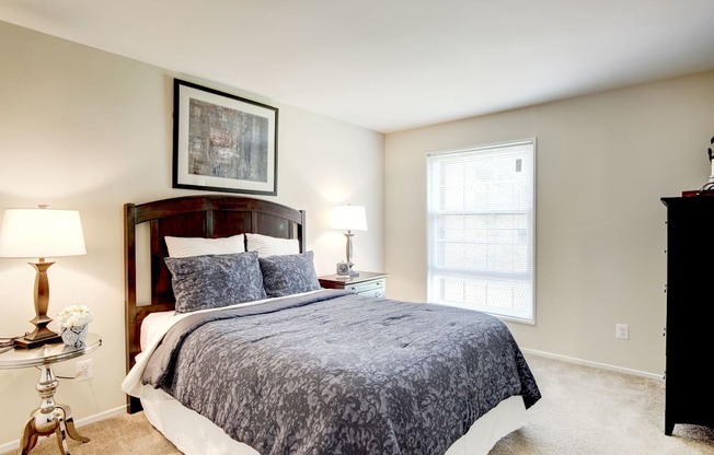 A bedroom with a large bed and a painting on the wall.