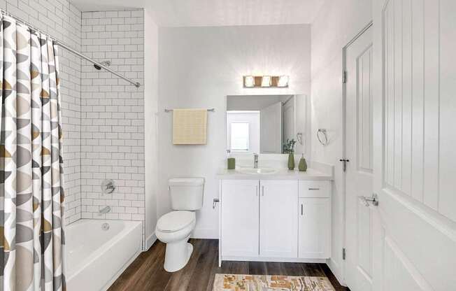 A white bathroom with a toilet, sink, and shower.
