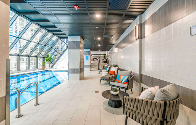 a lobby with a pool and lounge chairs