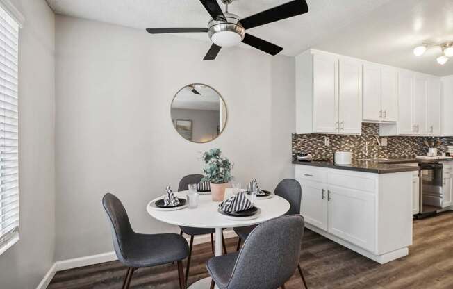 A dining room with a table, chairs, and a ceiling fan.