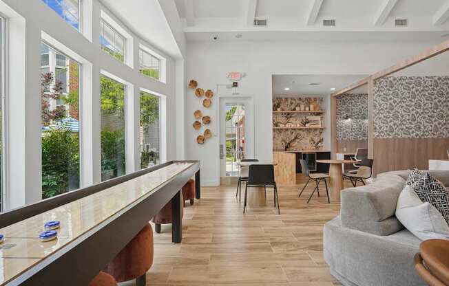 A modern living room with a long wooden table and a grey couch.