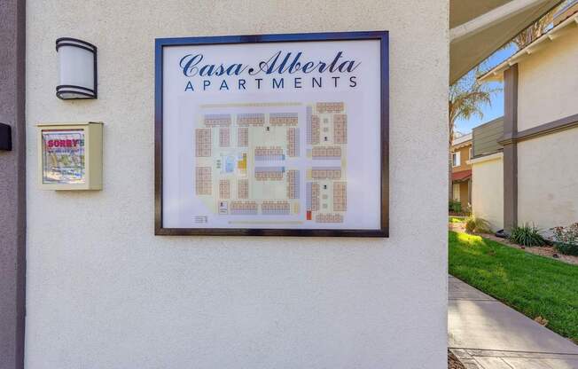 A framed picture of a floor plan for Casa Alberta Apartments is hanging on a wall.