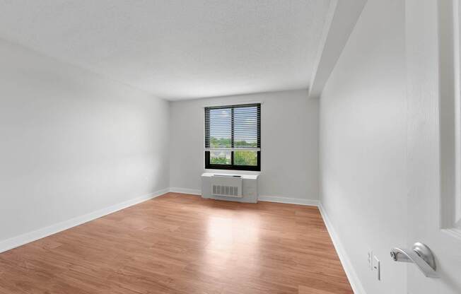 A room with a window and a radiator on the floor at Riverside Apartments, Alexandria, Virginia