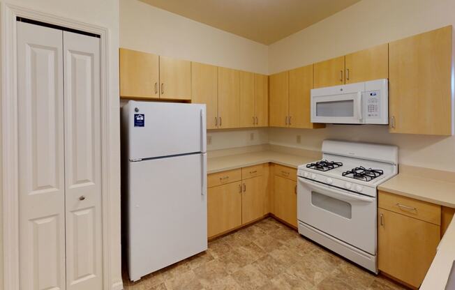 a kitchen with white appliances and wooden cabinets