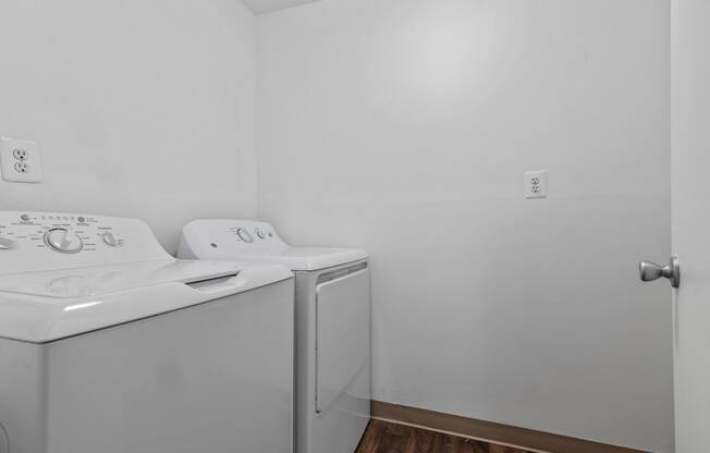 an empty laundry room with a washer and dryer and white walls at Edge At Farmington Hills - Farmington Hills, MI, Farmington Hills, Michigan