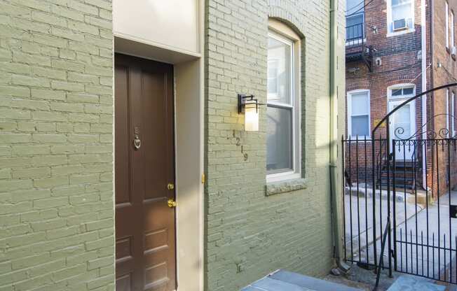 the front door of a brick house with a brown door