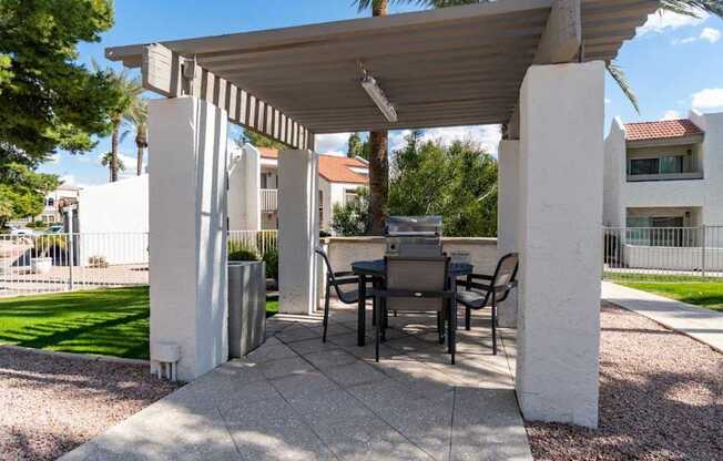 A patio with a table and chairs under a roof.