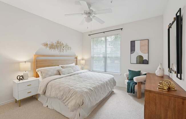 A bedroom with a large bed and a ceiling fan.