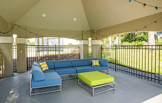 an outdoor patio with a blue couch and green ottoman