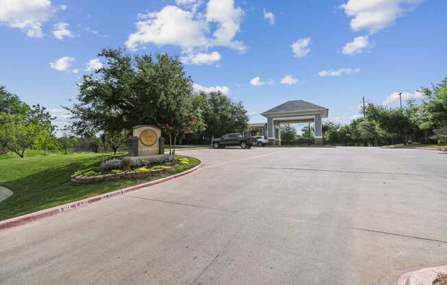 a parking lot with a sign and a building in the background at St. Augustine Estate, Dallas, TX