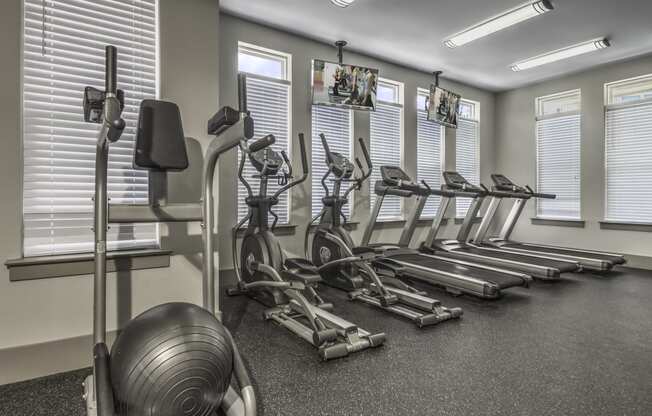 a gym with cardio machines and weights on the floor