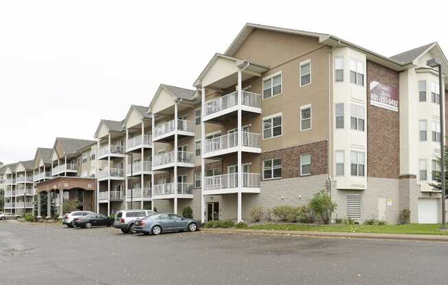 a picture of an apartment complex with cars parked in front of it