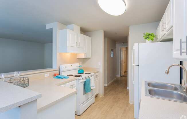a kitchen with white cabinets and a stove and a refrigerator at Sitka Heights in Fife
