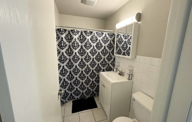 a bathroom with a toilet and a sink and a shower