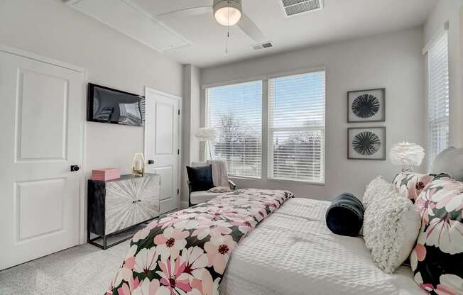 A bedroom with a large bed and a TV on the wall.