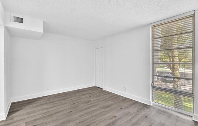 A room with a window and a wall-mounted air conditioner unit.
