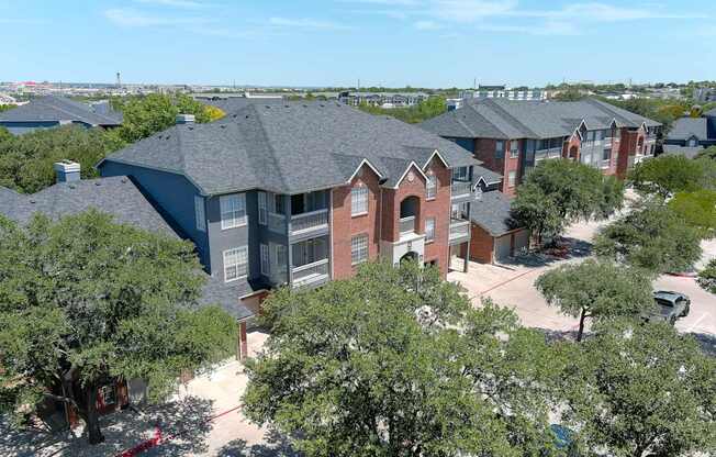 A bird's eye view of an apartment building surrounded by trees.
