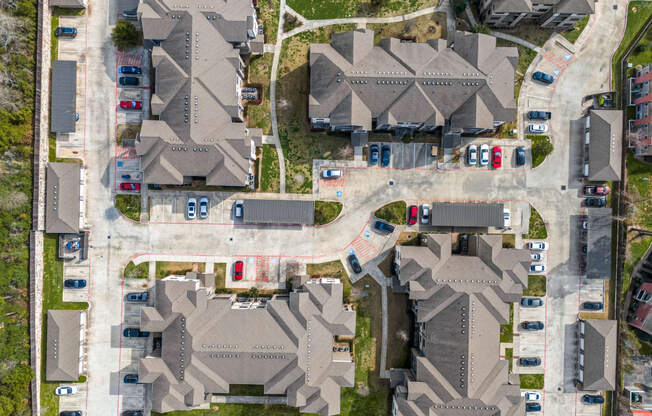 an aerial view of houses with cars parked on the street